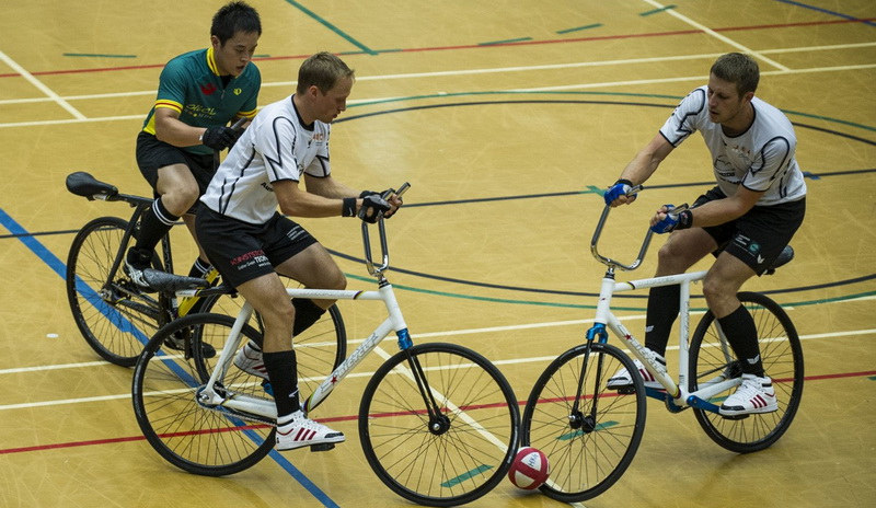 Tiga pemain sepak bola sepeda bersepeda